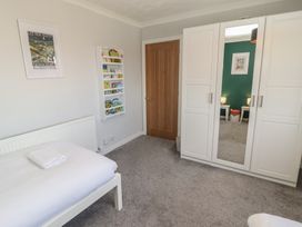 A bedroom with a bed and wardrobe at Ty Traeth in Porthcawl