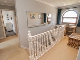 A hallway with a staircase and mirror at Ty Traeth in Porthcawl