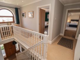 A hallway with a staircase and doorways at Ty Traeth in Porthcawl