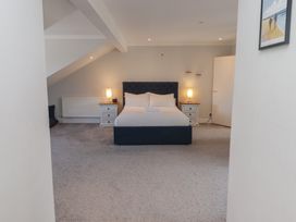 A bedroom with a bed, nightstands, and lamps at Ty Traeth in Porthcawl