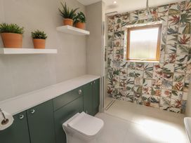 A bathroom with a shower and cabinet at Ty Traeth in Porthcawl