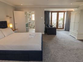 A bedroom with a bed and a sofa at Ty Traeth in Porthcawl