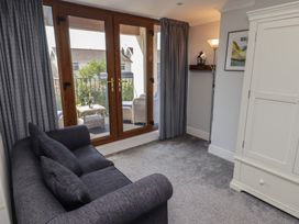A living room with a sofa and sliding door at Ty Traeth in Porthcawl