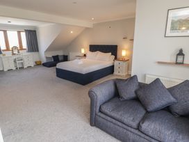 A bedroom with a bed and seating area at Ty Traeth in Porthcawl