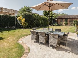 A garden with a dining area featuring a table and chairs at Ty Traeth in Porthcawl