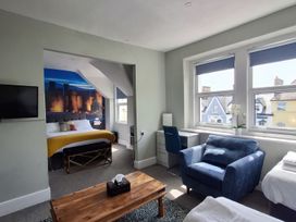 A bedroom with a bed and seating area at Holiday home guest house in Llandudno
