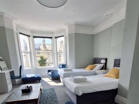 A bedroom with two beds and a desk at Holiday home guest house in Llandudno