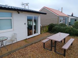 A garden with a table and chairs outside at Bay View Chalet 2 Bed Sleeps 4 Pets Garden Beach Wilsthorpe near Bridlington