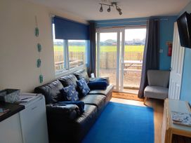 A living room with a sofa and sliding door at Bay View Chalet 2 Bed Sleeps 4 Pets Garden Beach Wilsthorpe near Bridlington