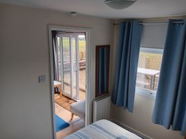 A bedroom with a bed and mirror at Bay View Chalet 2 Bed Sleeps 4 Pets Garden Beach in Wilsthorpe near Bridlington