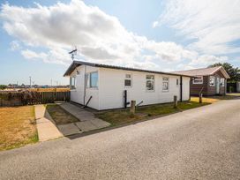 An outdoor view of a cabin by the sidewalk at Bay View Chalet 2 Bed Sleeps 4 Pets Garden Beach Wilsthorpe near Bridlington
