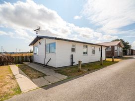 A house with windows beside a pathway at Bay View Chalet 2 Bed Sleeps 4 Pets Garden Beach Wilsthorpe near Bridlington
