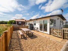 An outdoor area with a table and chairs at Bay View Chalet 2 Bed Sleeps 4 Pets Garden Beach Wilsthorpe near Bridlington