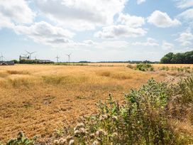 A field with wind turbines in the background at Bay View Chalet 2 Bed Sleeps 4 Pets Garden Beach, Wilsthorpe near Bridlington