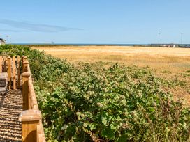 A view of an ocean and field with a fence at Bay View Chalet 2 Bed Sleeps 4 Pets Garden Beach Wilsthorpe near Bridlington