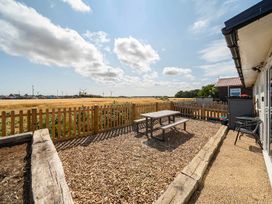 A garden with a table and chairs at Bay View Chalet 2 Bed Sleeps 4 Pets Garden Beach Wilsthorpe near Bridlington