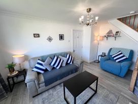 A living room with a sofa, armchair, and coffee table at 2 Bed Family Bungalow, WiFi, Parking, Garden, Dogs in Pentraeth