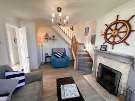 A living room with an armchair and staircase at 2 Bed Family Bungalow, WiFi, Parking, Garden, Dogs, Pentraeth