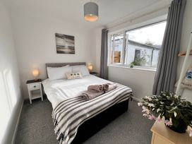 A bedroom with a bed and a window at 2 Bed Family Bungalow, WiFi, Parking, Garden, Dogs, Pentraeth