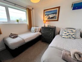 A bedroom with two single beds and a chest of drawers at 2 Bed Family Bungalow, WiFi, Parking, Garden, Dogs, Pentraeth