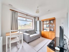 A living room with a sofa and a bookshelf at Sleeps 9 KingBeds Family Friendly, Pityme near Penmayne