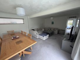 A living room with a dining table and sofa at Sleeps 9 KingBeds Family Friendly, Pityme near Penmayne