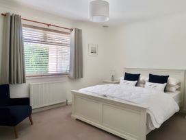 A bedroom with a bed and an armchair at Sleeps 9 KingBeds Family Friendly in Pityme near Penmayne