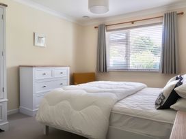A bedroom with a bed and dresser at Sleeps 9 KingBeds Family Friendly, Pityme near Penmayne