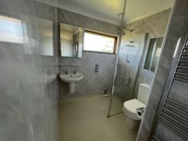 A bathroom with a shower, sink, and toilet at Sleeps 9 KingBeds Family Friendly in Pityme near Penmayne
