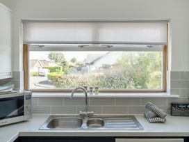 A kitchen with a sink and window at Sleeps 9 KingBeds Family Friendly in Pityme near Penmayne