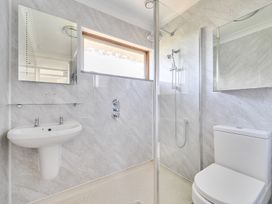 A bathroom with a sink, shower, and toilet at Sleeps 9 KingBeds Family Friendly in Pityme near Penmayne