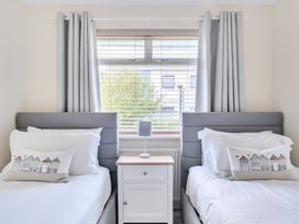 A bedroom with two beds and a bedside table at Sleeps 9 KingBeds Family Friendly in Pityme near Penmayne