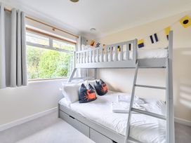 A bedroom with a bunk bed and decorative pillows at Sleeps 9 KingBeds Family Friendly in Pityme near Penmayne