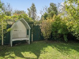 A garden with a bench and trees at Sleeps 9 KingBeds Family Friendly in Pityme near Penmayne