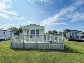 A caravan with a deck and grass area at Super 2 bed 6 berth caravan pets go free in Hunstanton