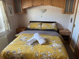 A bedroom with a bed and bedside table at Super 2 bed 6 berth caravan pets go free, Hunstanton