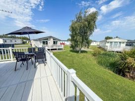 An outdoor seating area with a table and umbrella at Super 2 bed 6 berth caravan pets go free in Hunstanton