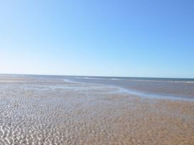 A beach with wet sand and water at Super 2 bed 6 berth caravan pets go free Hunstanton