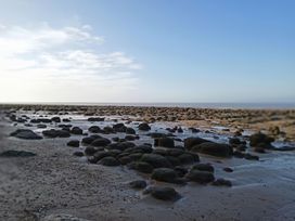 A beach with rocks and sand at Super 2 bed 6 berth caravan pets go free Hunstanton