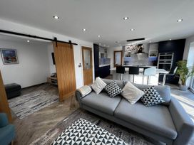 A living room with a sofa and kitchen area at a property
