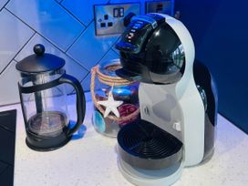 A coffee machine and French press on a kitchen counter
