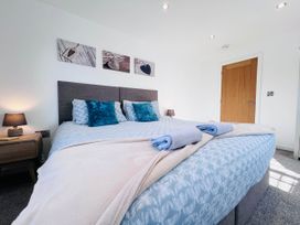 A bedroom with a large bed and bedside table at the property in the location