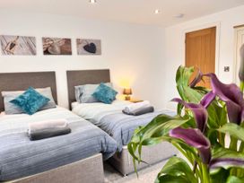 A bedroom with two beds, pillows, and a plant at the property