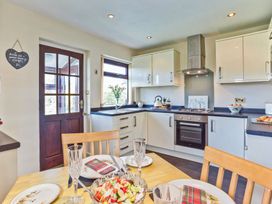 A kitchen with a dining table set at Lothlorien in Grange over Sands