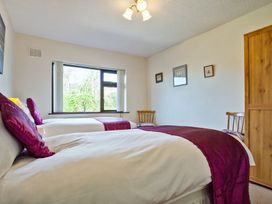 A bedroom with two beds and a window at Lothlorien in Grange over Sands