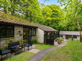 An outdoor view of a cabin with seating and trees at Painters Cottage 2Bed Chalet Free Leisure Passes Near St Ives