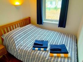 A bedroom with a bed and towels at Painters Cottage 2Bed Chalet Free Leisure Passes Near St Ives