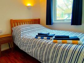 A bedroom with a bed and towels on it at Painters Cottage 2Bed Chalet Free Leisure Passes Near St Ives