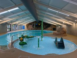 An indoor pool with water features and play equipment at Painters Cottage 2Bed Chalet Free Leisure Passes Near St Ives