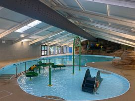 An indoor swimming pool with water slides and play area at Painters Cottage 2Bed Chalet Free Leisure Passes Near St Ives